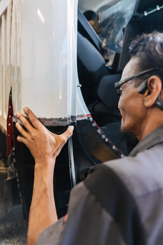 A technician refitting body trim after a repair