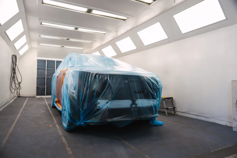 A vehicle fully masked and covered, ready for refinishing
