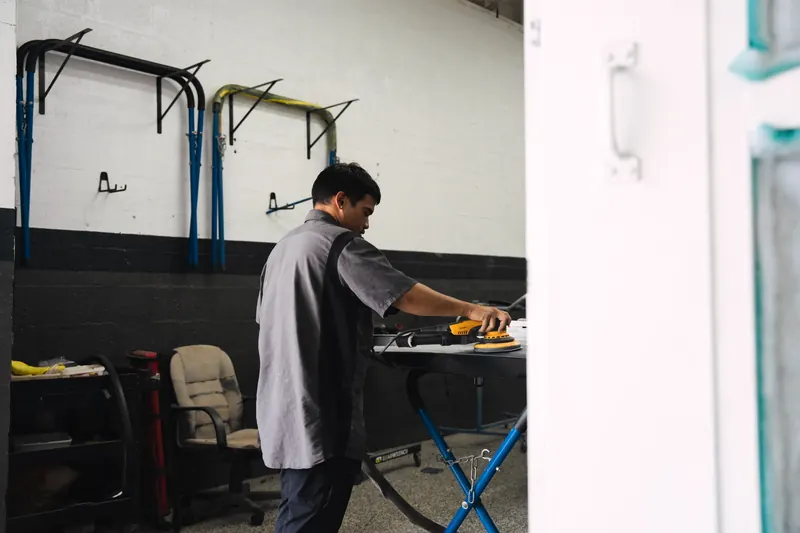 A technician repairing a body panel at 417 Autoworks